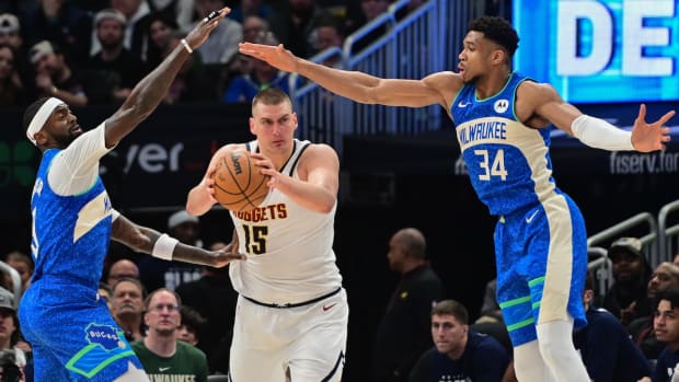 Denver Nuggets center Nikola Jokic (15) is pressured by Milwaukee Bucks forward Bobby Portis (9) and forward Giannis Antetokounmpo (34) in the second quarter at Fiserv Forum in Milwaukee on Feb. 12, 2024.